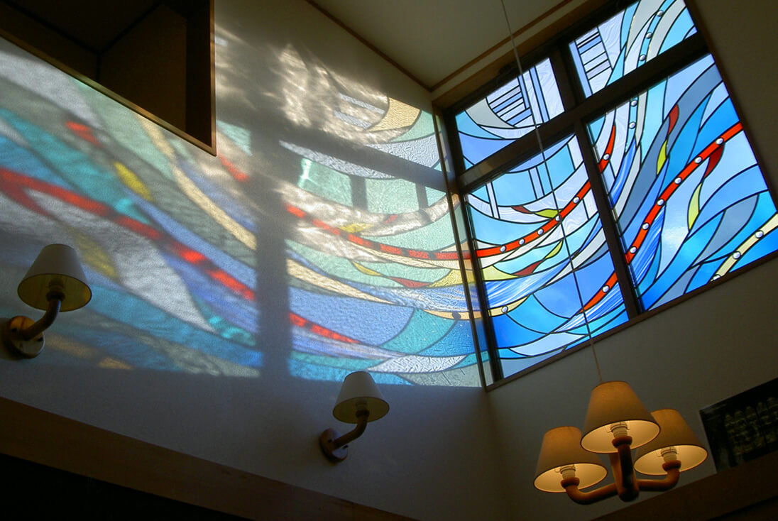 個人邸宅 抽象（流れのあるデザイン）-001 側壁に光が映り込むステンドグラスの様子