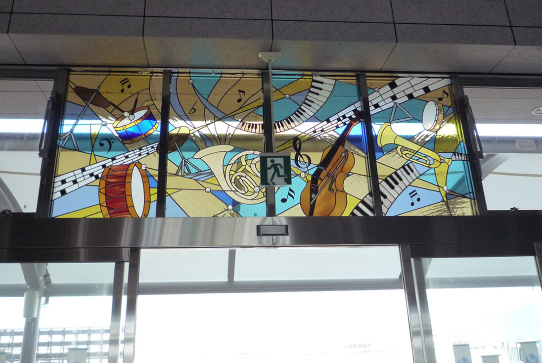 JR九州 九州新幹線 新玉名駅 グレンミラー、楽器(チェロ、トランペット、シンバル、ドラム、ピアノ)、音楽などをデザインしたステンドグラス
