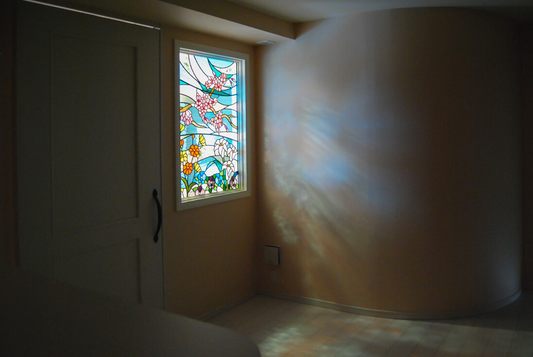 空と花をモチーフにデザインしたステンドグラスに光が入る様子