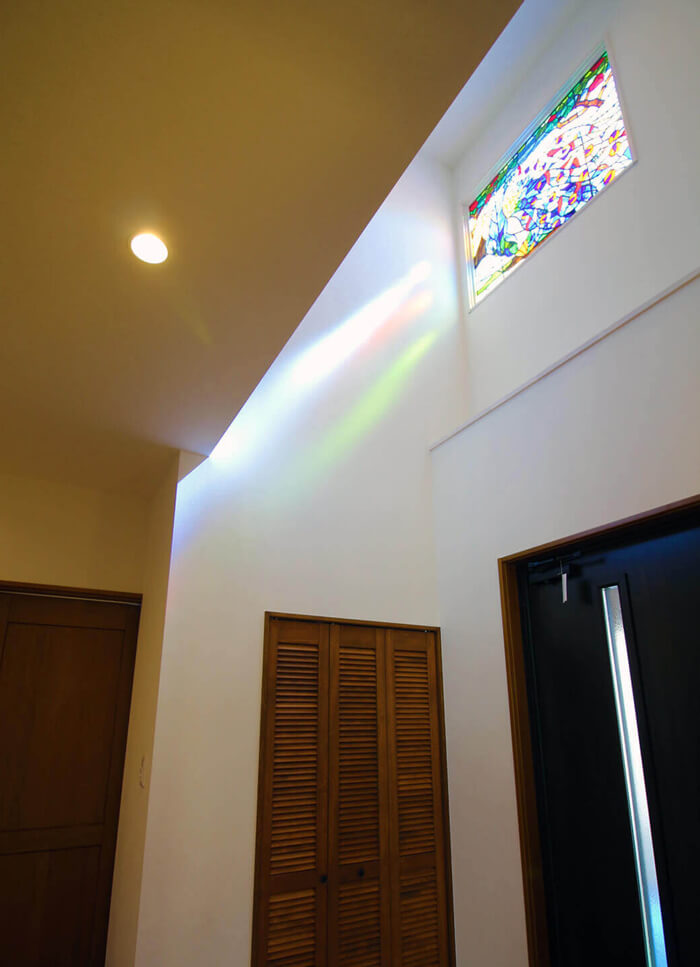 吹き抜けのステンドグラスを階段、玄関から撮影したイメージ