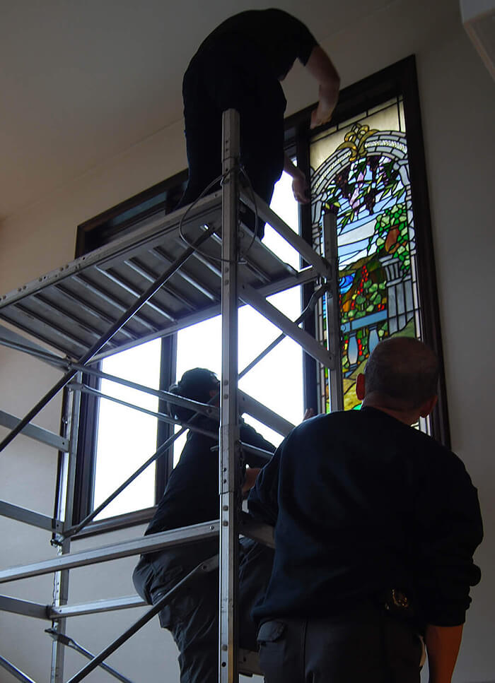 「ティファニースタイル湖畔の風景」を既存の窓に取り付けている様子