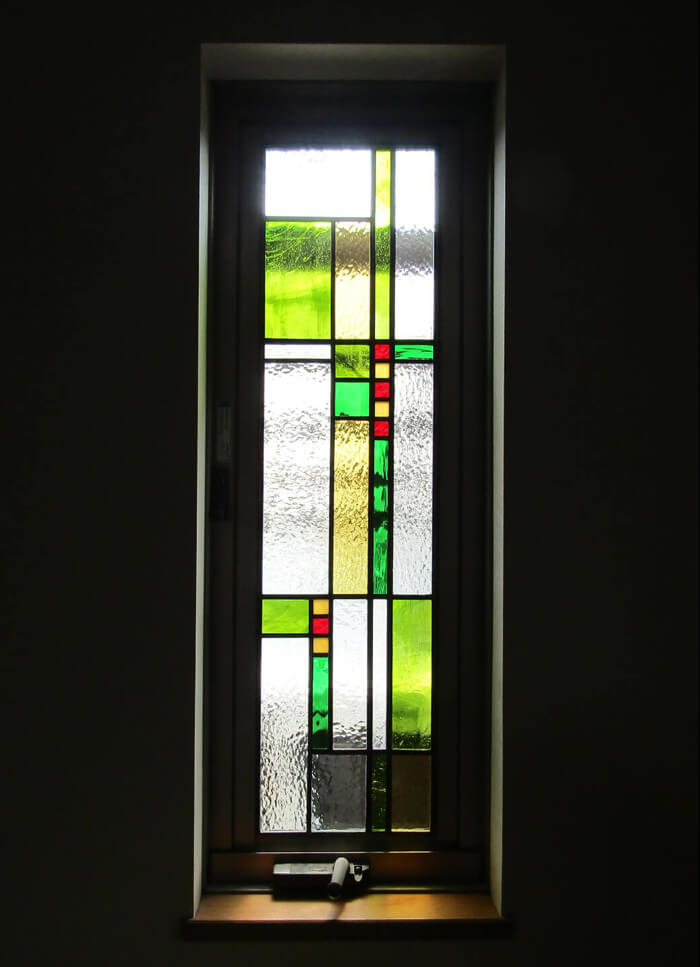 窓に取り付けたシンプルな幾何学デザインのステンドグラス（グリーン系）