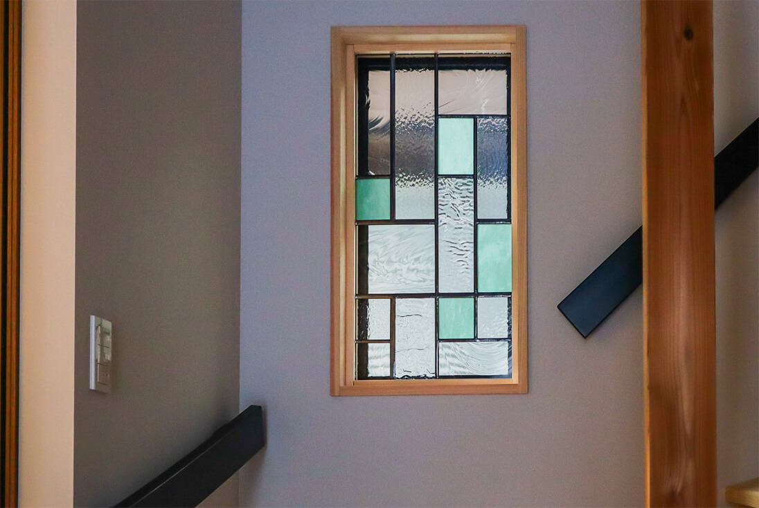 新築住宅の階段横の壁に取り付けた幾何学デザインのステンドグラス（W350×H710）