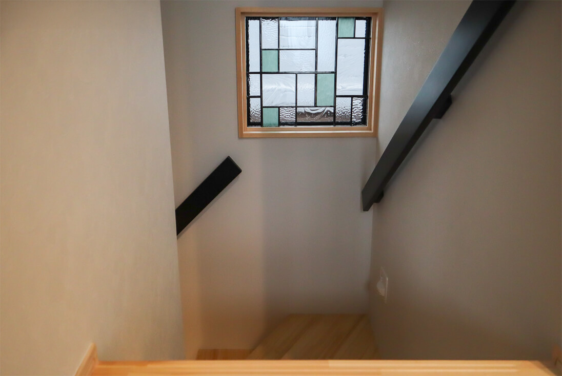 新築住宅の階段横の壁に取り付けた幾何学デザインのステンドグラス（W580×H510）