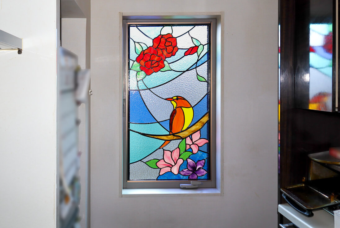 キッチンに取り付けた、鳥とバラ、ツツジをデザインしたステンドグラス