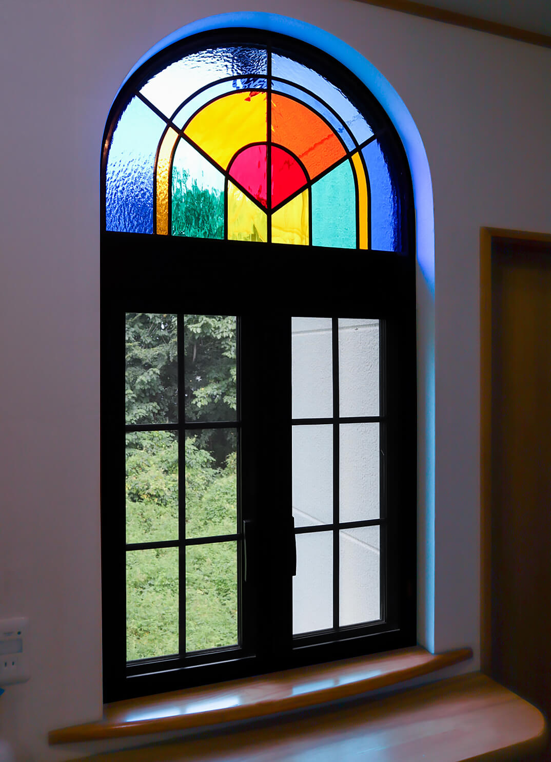 アーチ型の窓に取り付けたシンプルなデザインのステンドグラス