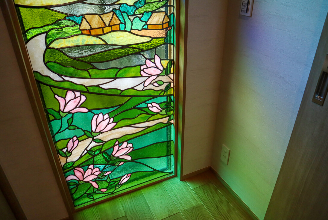 作品下部モクレン部分のステンドグラスに自然光が差し込み、室内に色鮮やかなやさしい光が照らされているイメージ